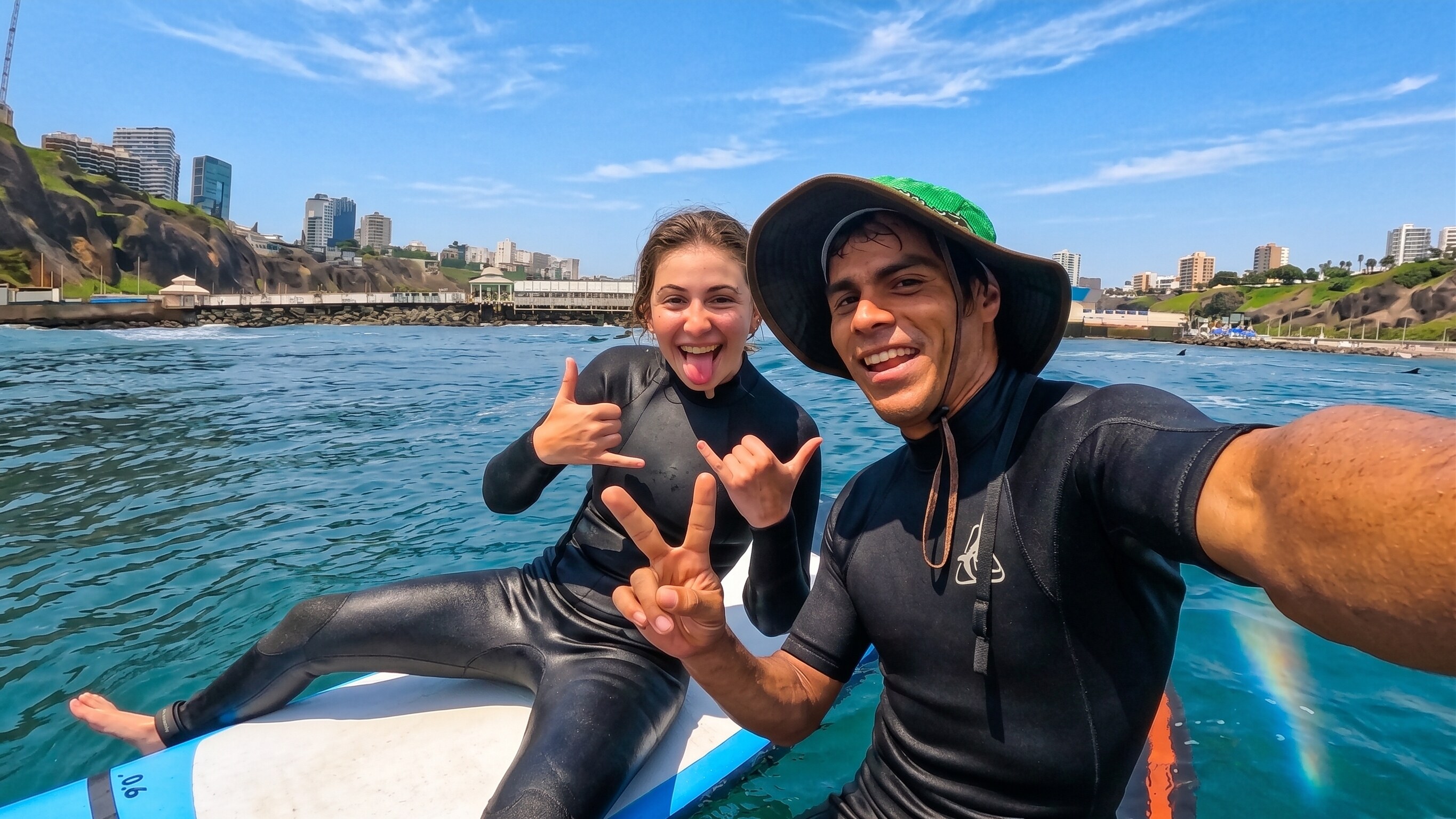 Monkey Surf instructor and student on a surfboard in the water off Lima